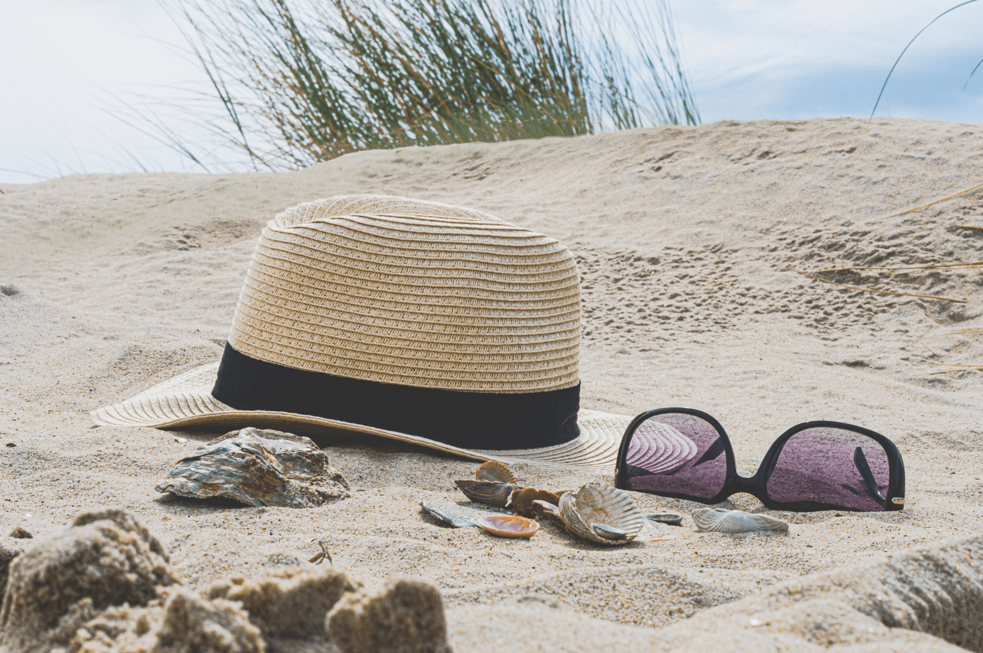 chapeau de paille et lunettes de soleil à la plage