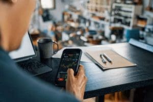 smart-phone-to-monitor-his-cryptocurrency-and-stock-trading